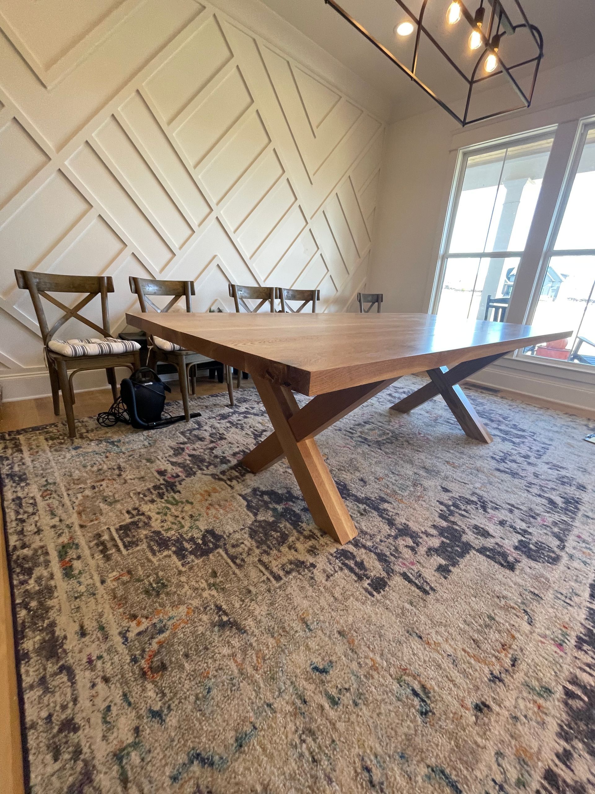 A wooden table is sitting on top of a rug in a dining room.