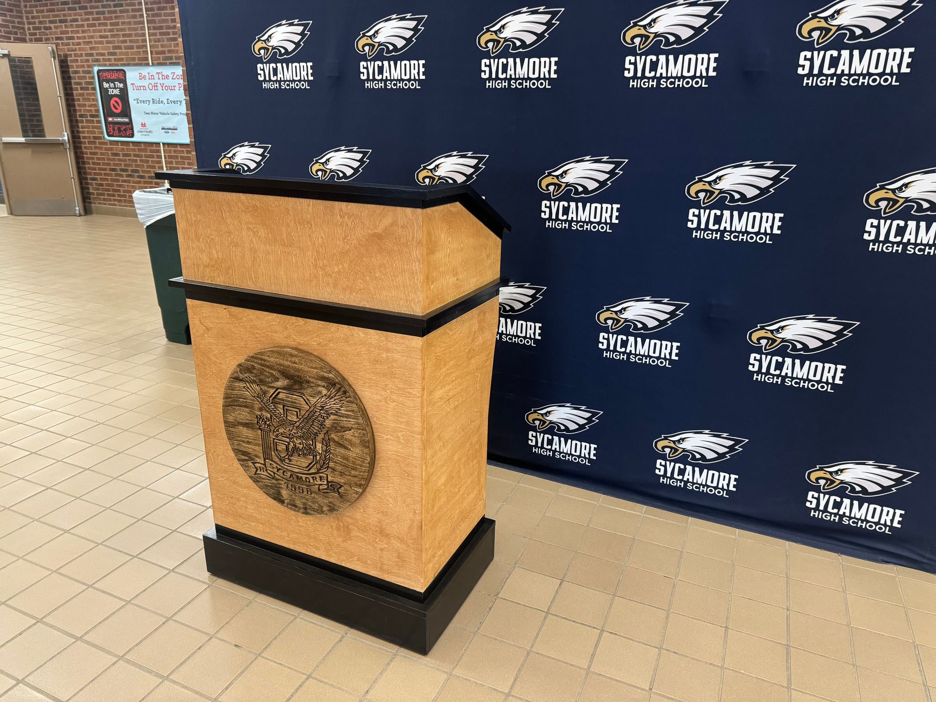 A podium is sitting in front of a wall with eagles on it.