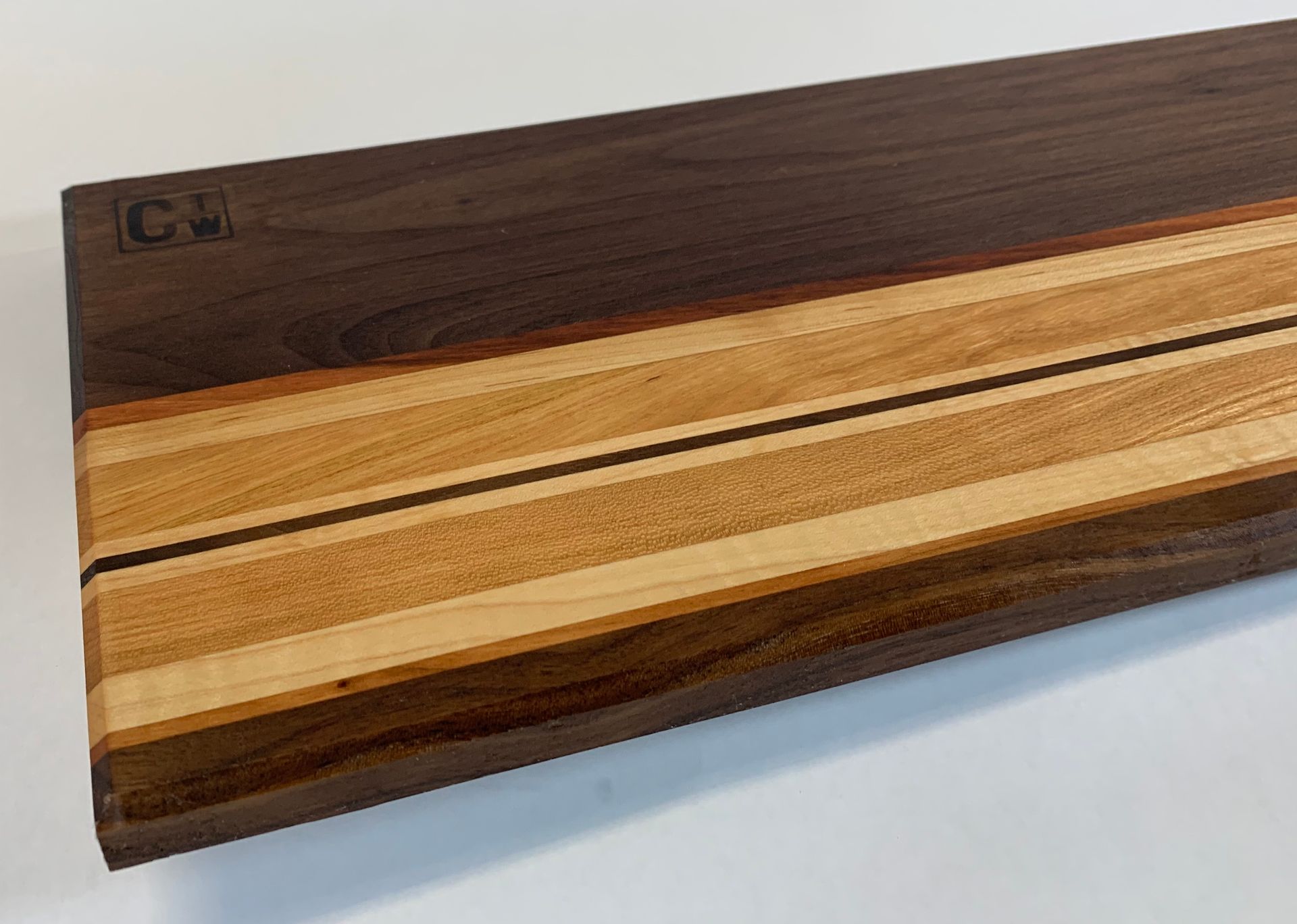 A wooden cutting board with three different types of wood on it
