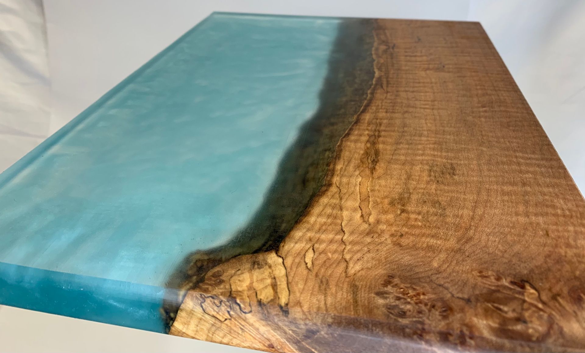 A piece of wood with a blue resin coating on it.