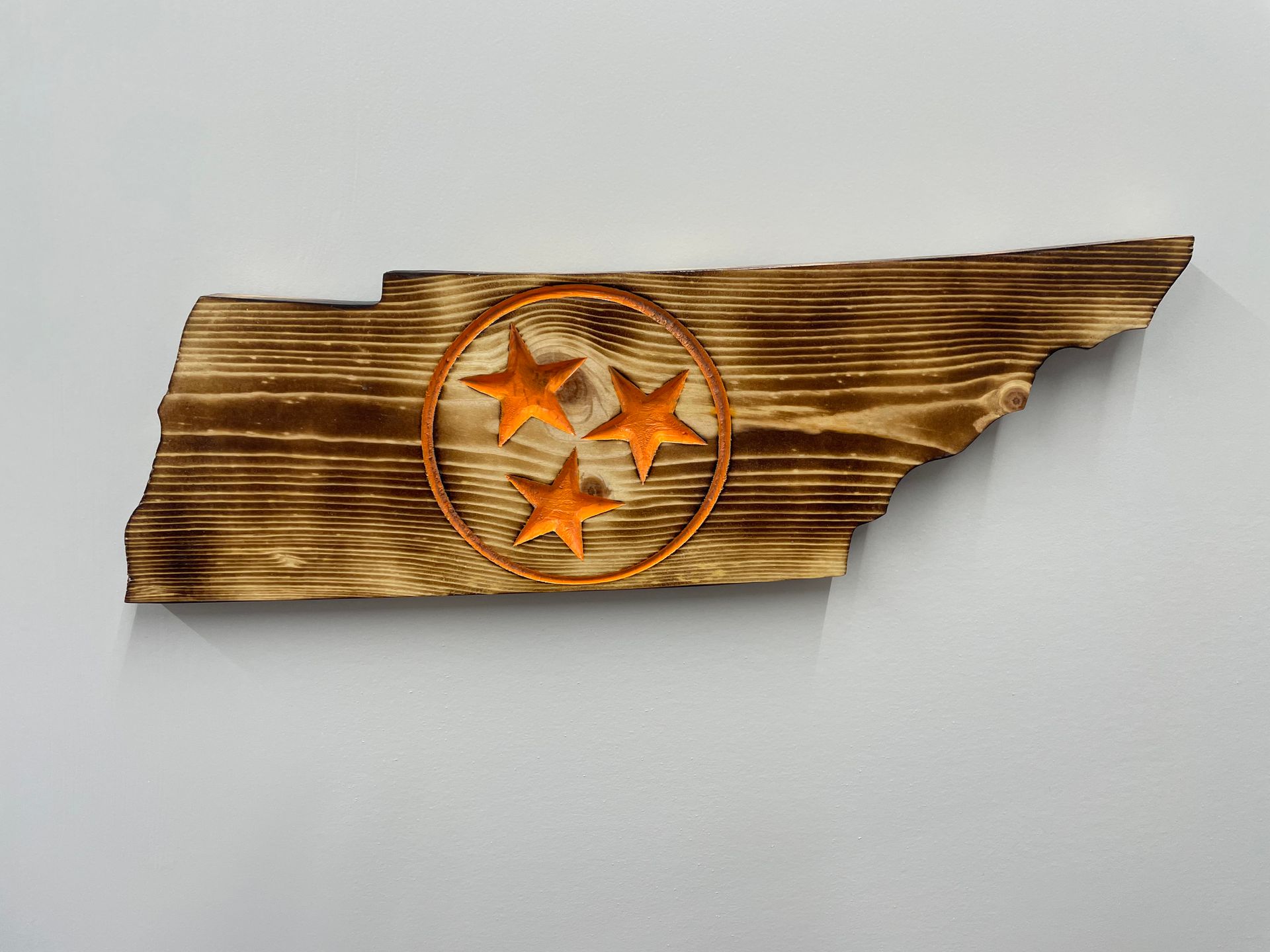 A wooden map of tennessee with the state flag carved into it.