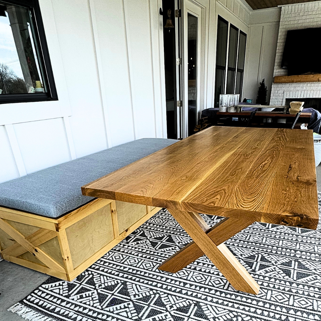 A wooden table with a bench underneath it in a living room.