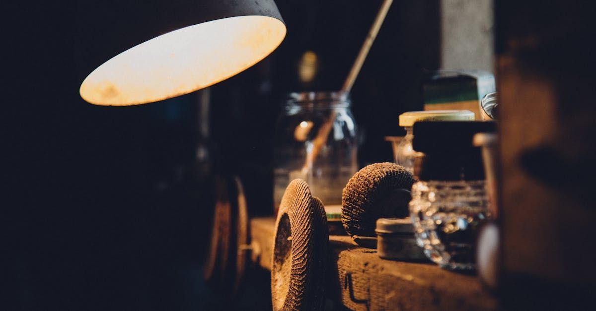 A lamp is sitting on a table next to a jar of sponges.