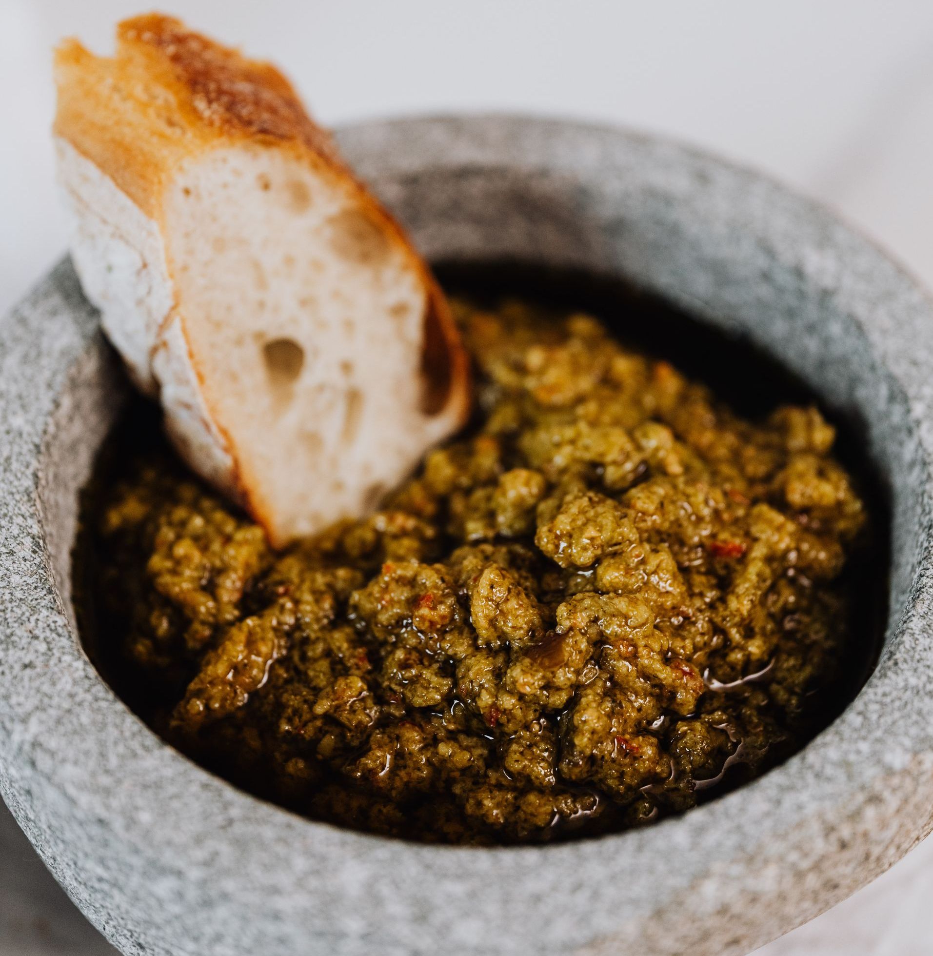 A slice of bread is sticking out of a bowl of food