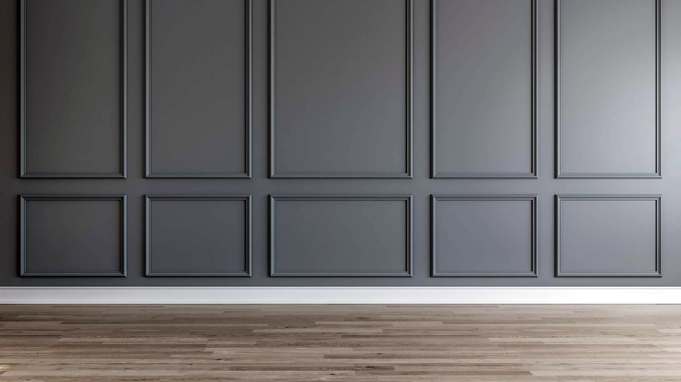 Gray paneled wall with a wooden floor.