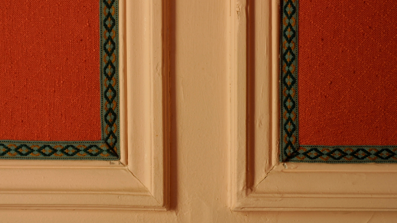 Orange textured panels framed with cream molding and teal trim.