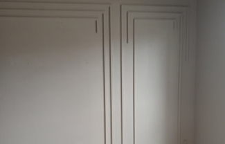 Two white wall panels with recessed geometric trim.