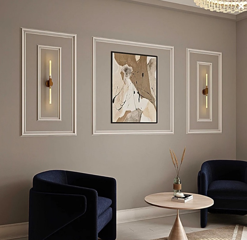 Living room with art, sconces, and two blue armchairs. Neutral walls, round table, modern style.