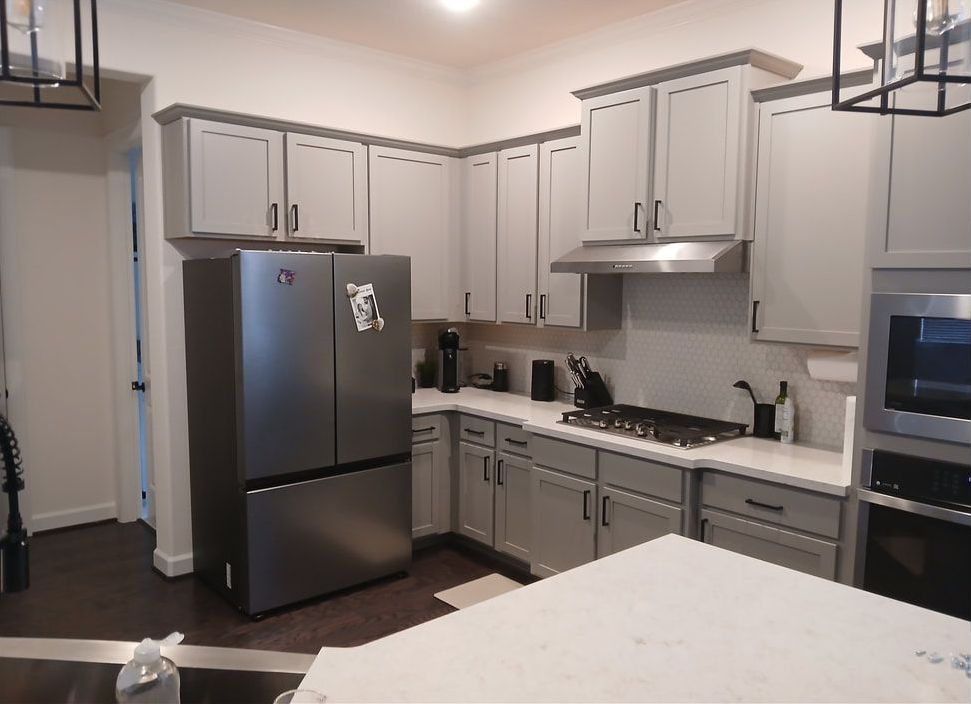 Kitchen with gray cabinets, stainless steel appliances, and a white countertop.