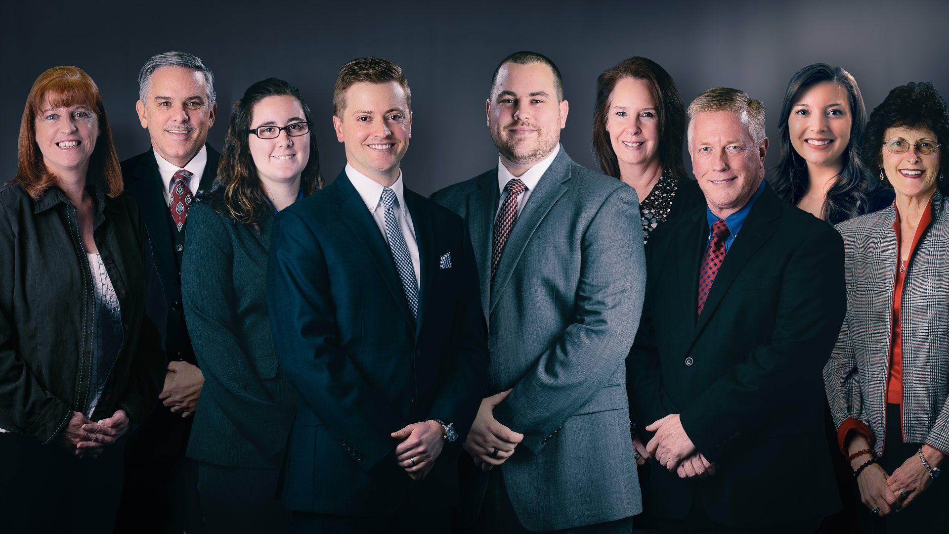 A group of people in suits and ties are posing for a picture.