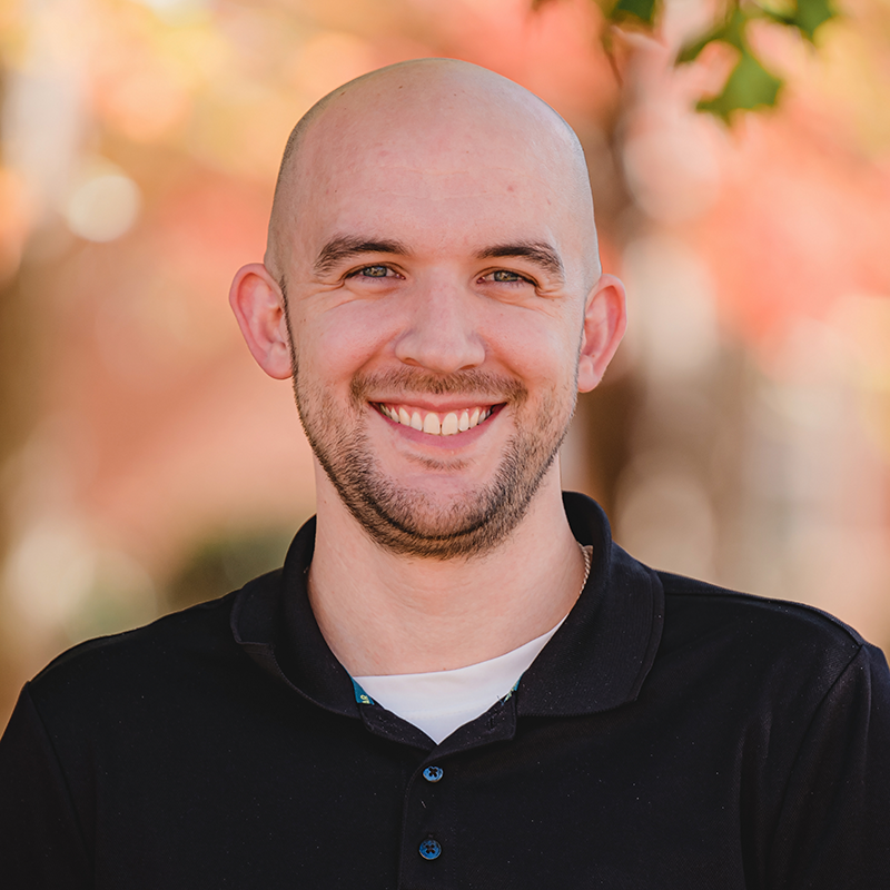 A bald man with a beard is smiling for the camera.