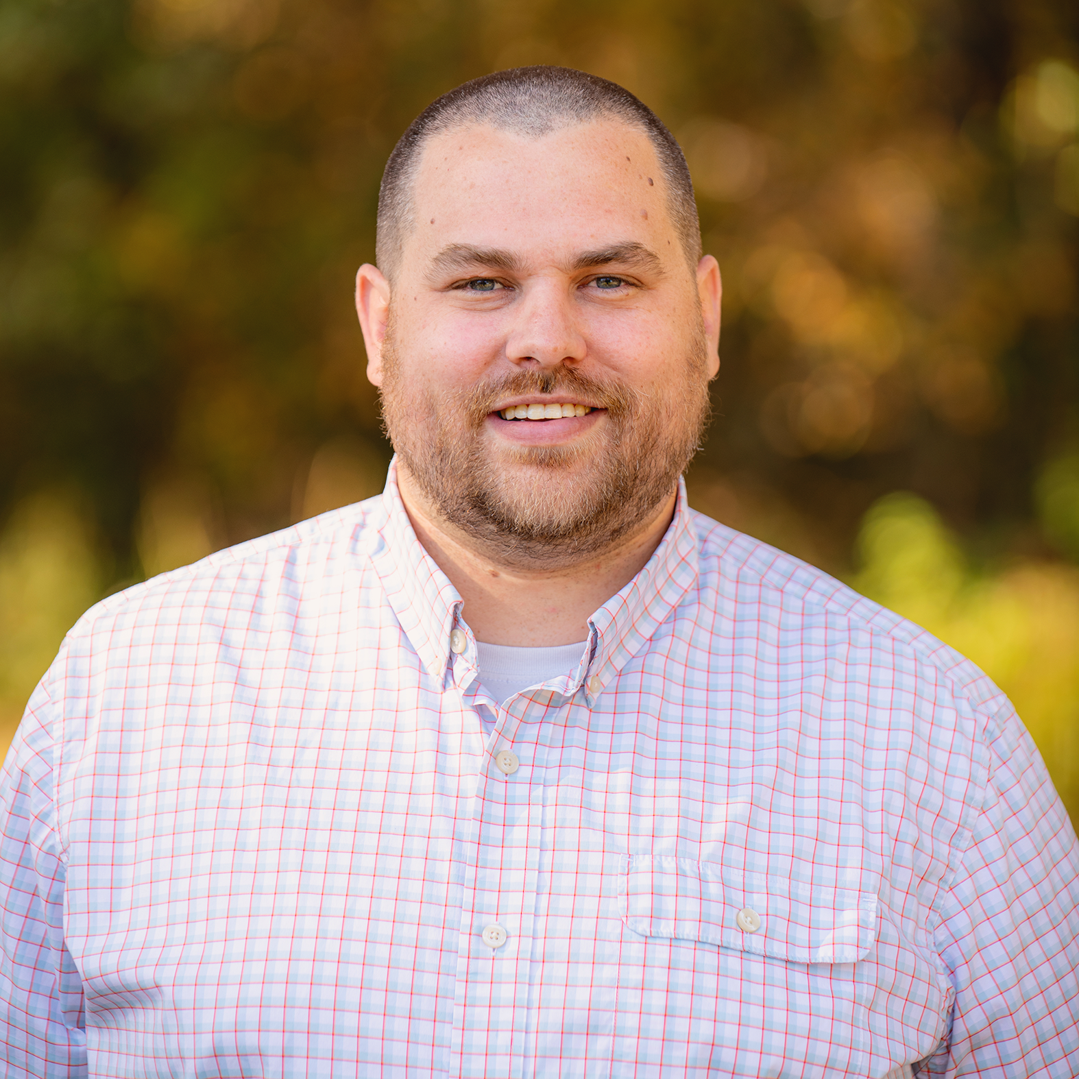 A man in a striped shirt is smiling for the camera.