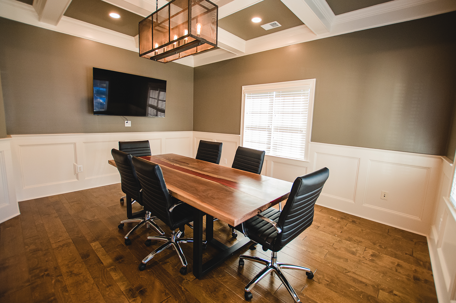 A conference room with a long wooden table and chairs.