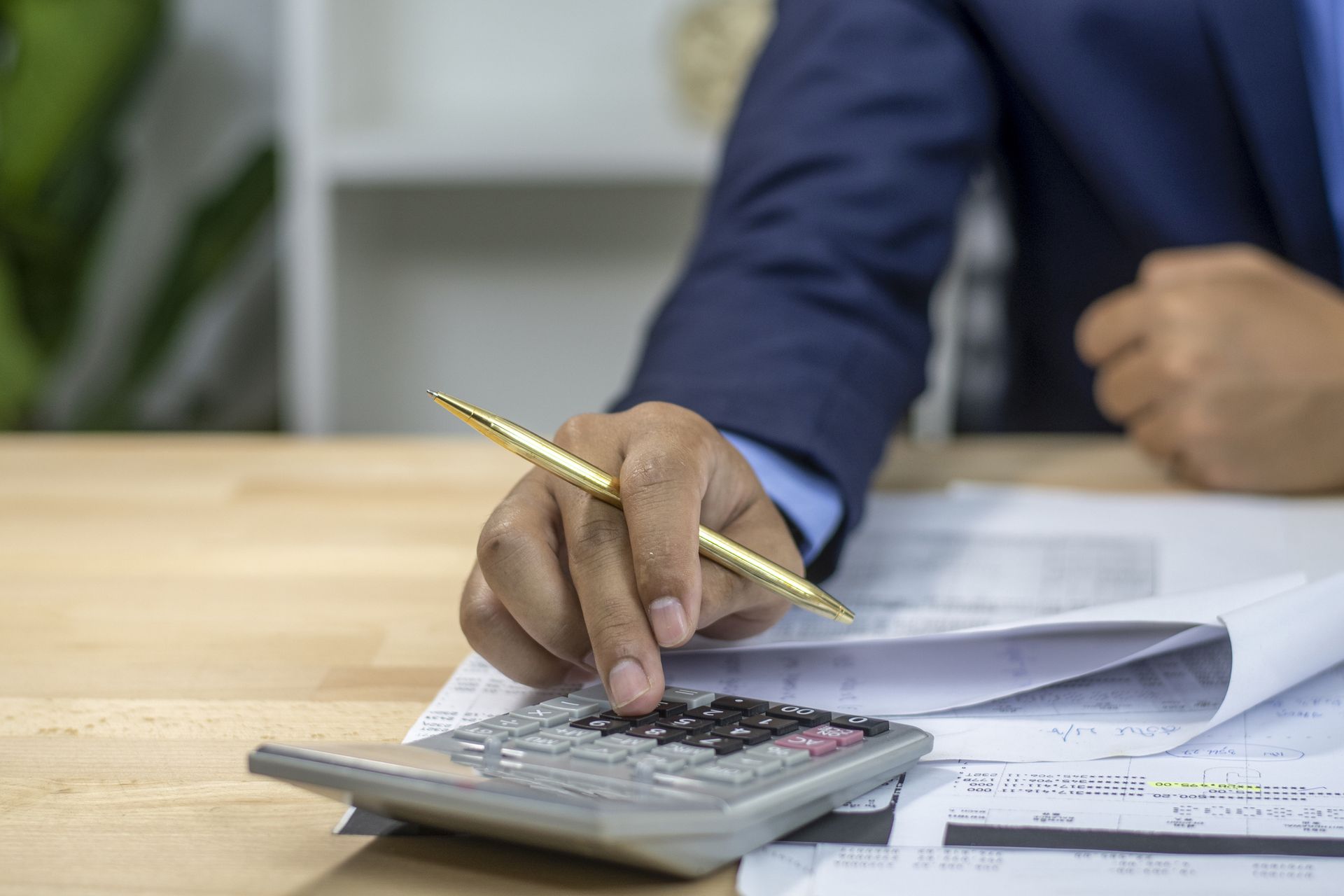 Tax accountant using a calculator to analyze data and ensure precise business calculations. Tax accountant using a calculator to analyze data and ensure precise business calculations.
