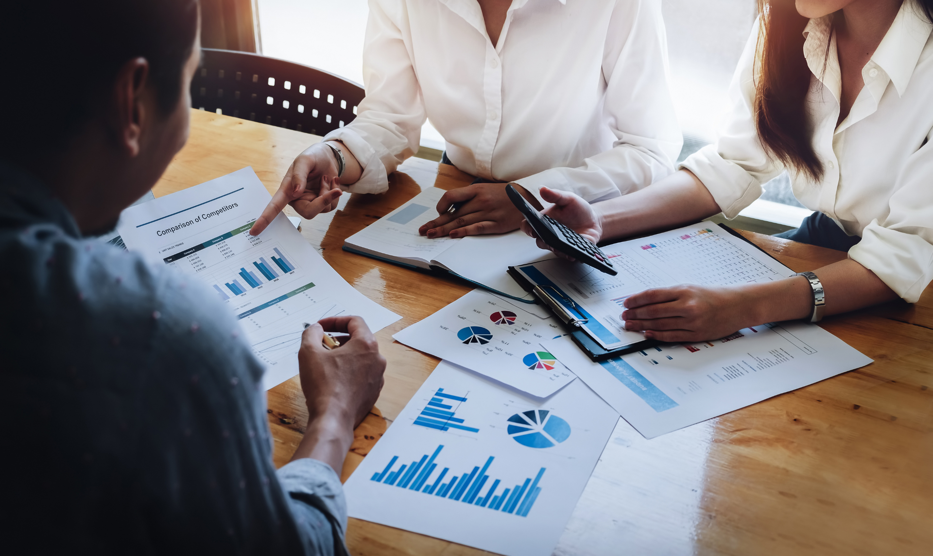 A group of people are sitting around a table looking at papers.