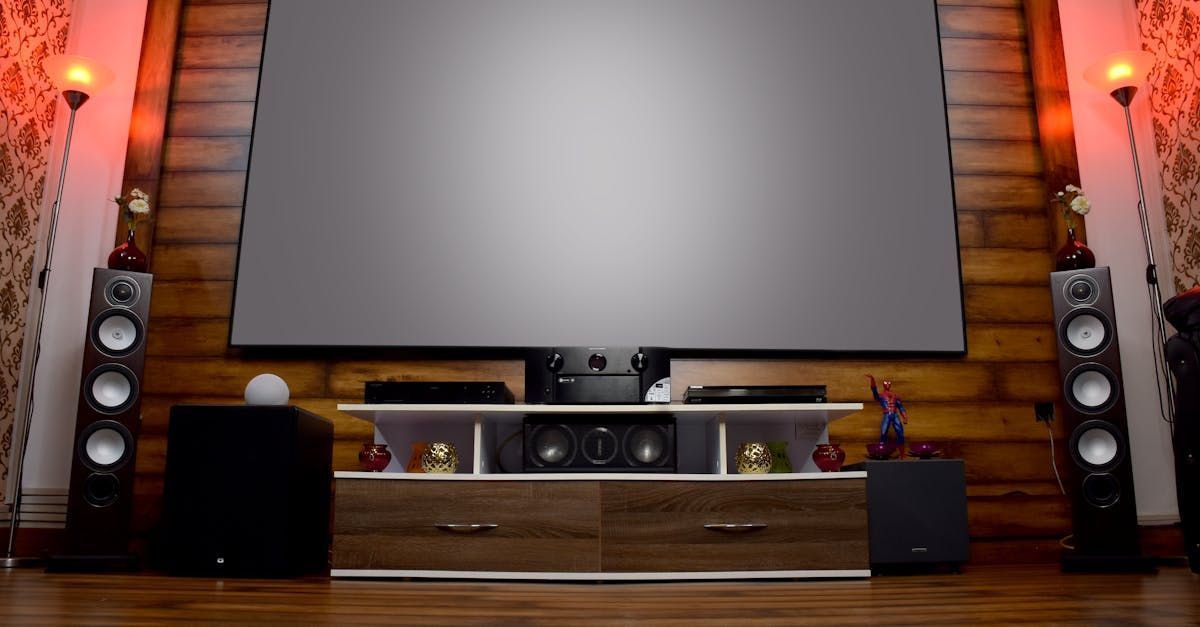 A large flat screen tv is sitting on top of a wooden entertainment center.