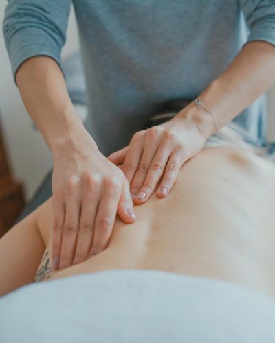 Man is Giving a Woman a Massage on Her Back — Mullumbimby Comprehensive Health Centre in Mullumbimby