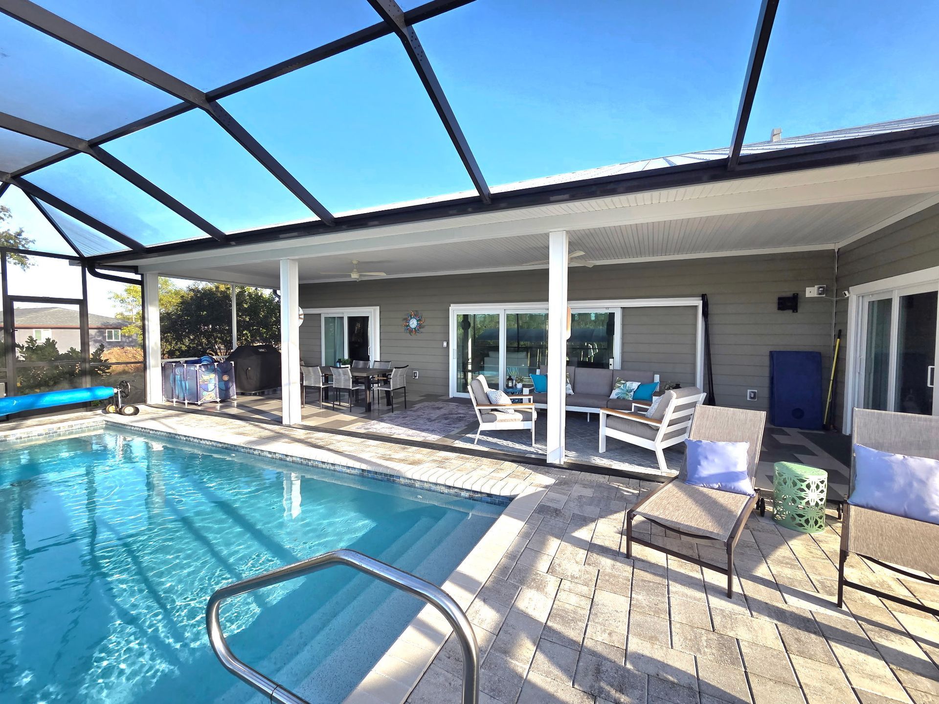 There is a large swimming pool in the backyard of a house.