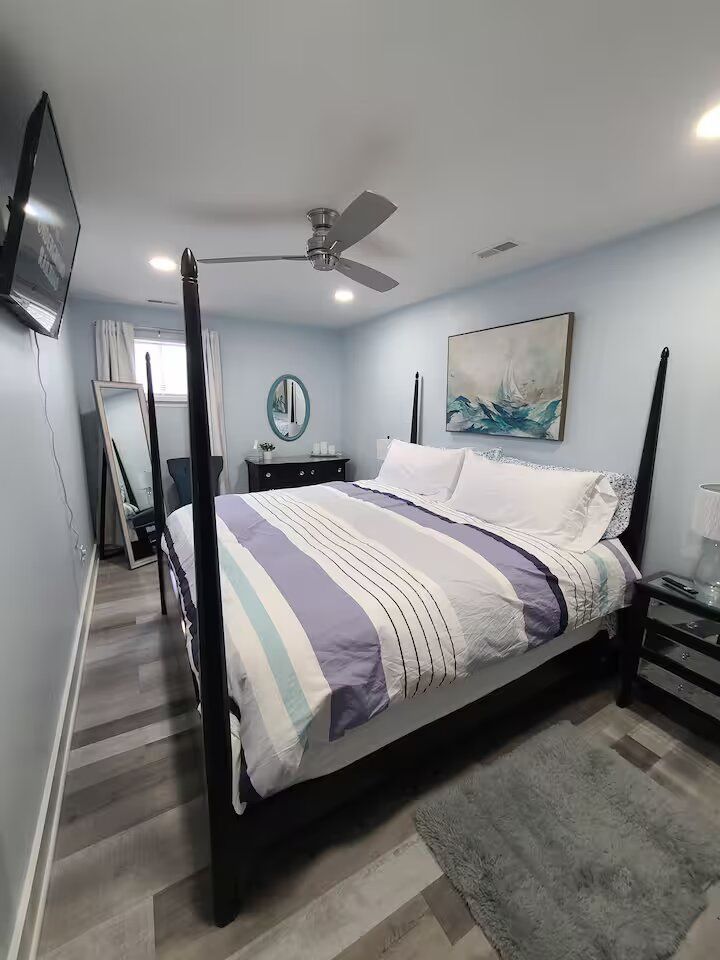 A bedroom with a four poster bed and a ceiling fan.