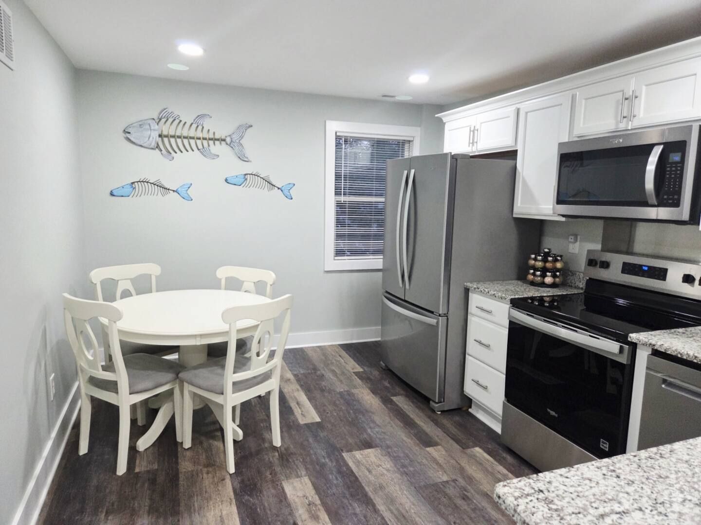 A kitchen with stainless steel appliances and black cabinets.