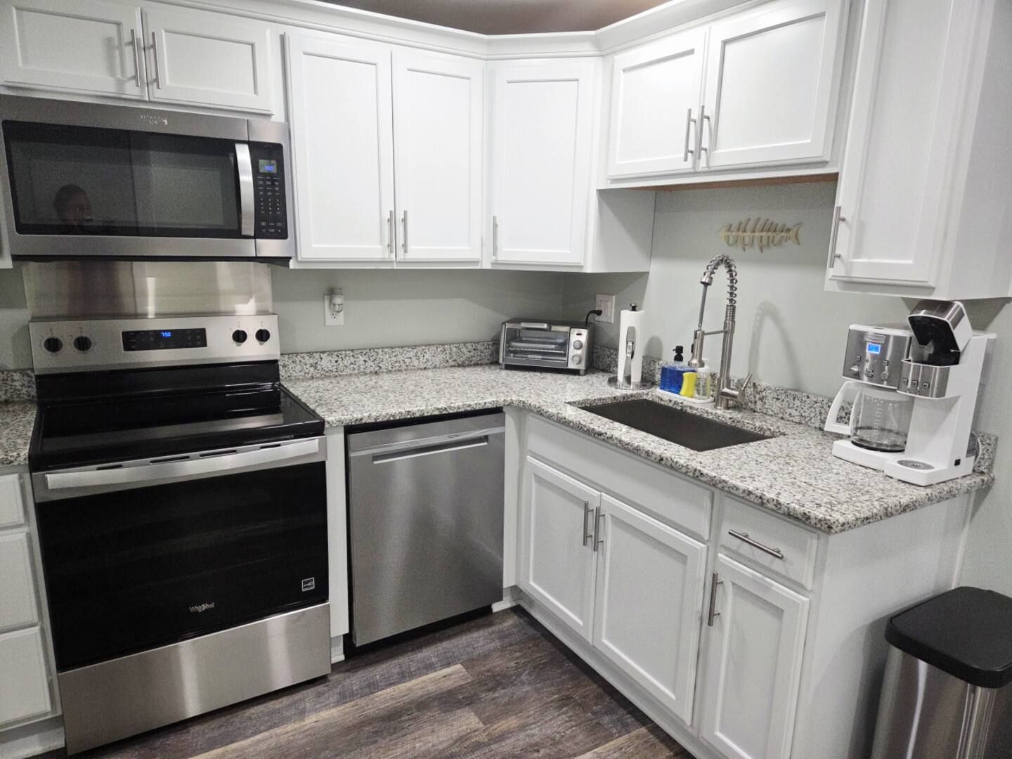 A patio with a gazebo , table and chairs and an umbrella.