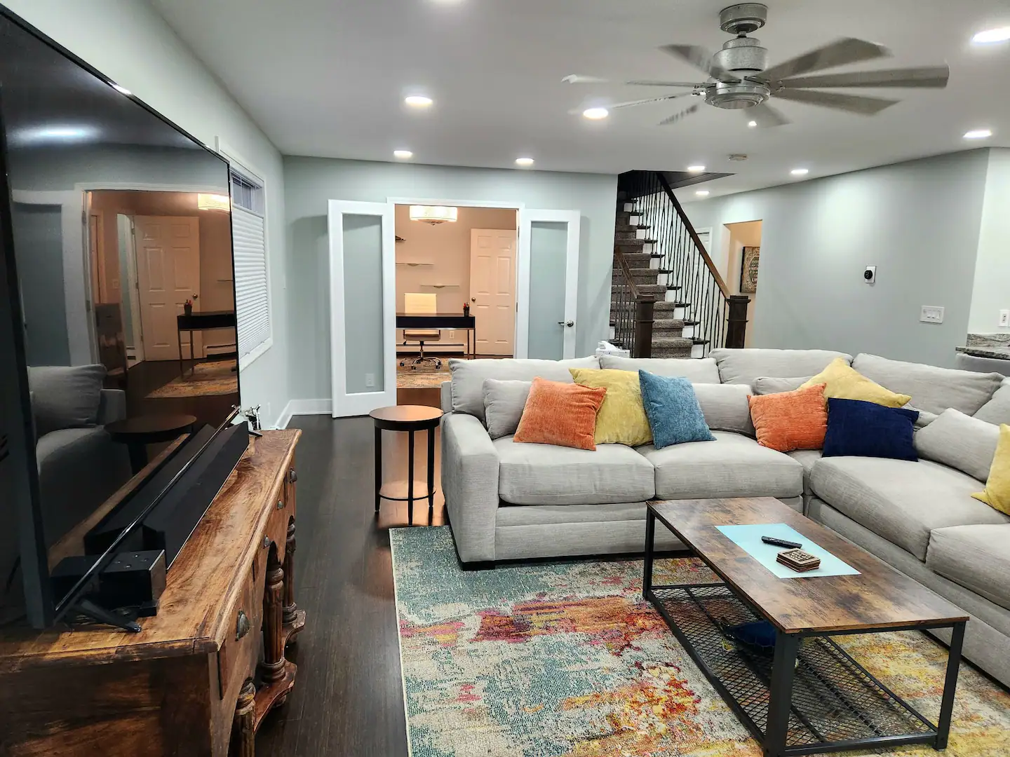 A living room with a large sectional couch and a flat screen tv