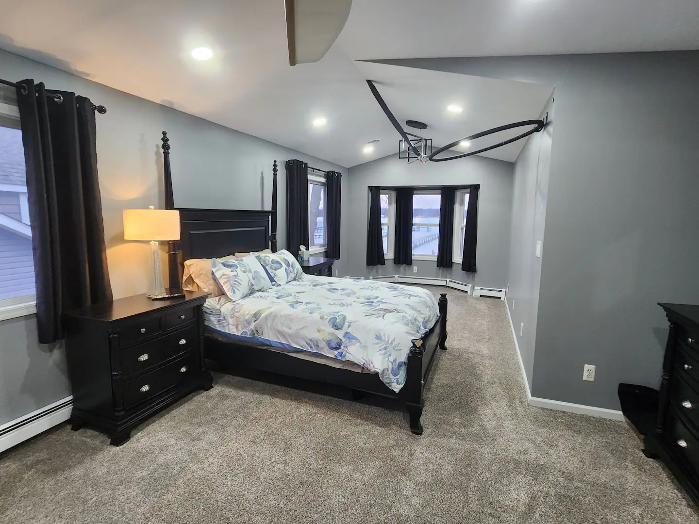 A bedroom with a king size bed, nightstand, and dresser