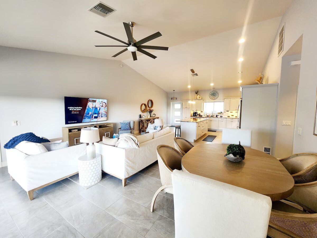 A living room and dining room in a house with a ceiling fan.