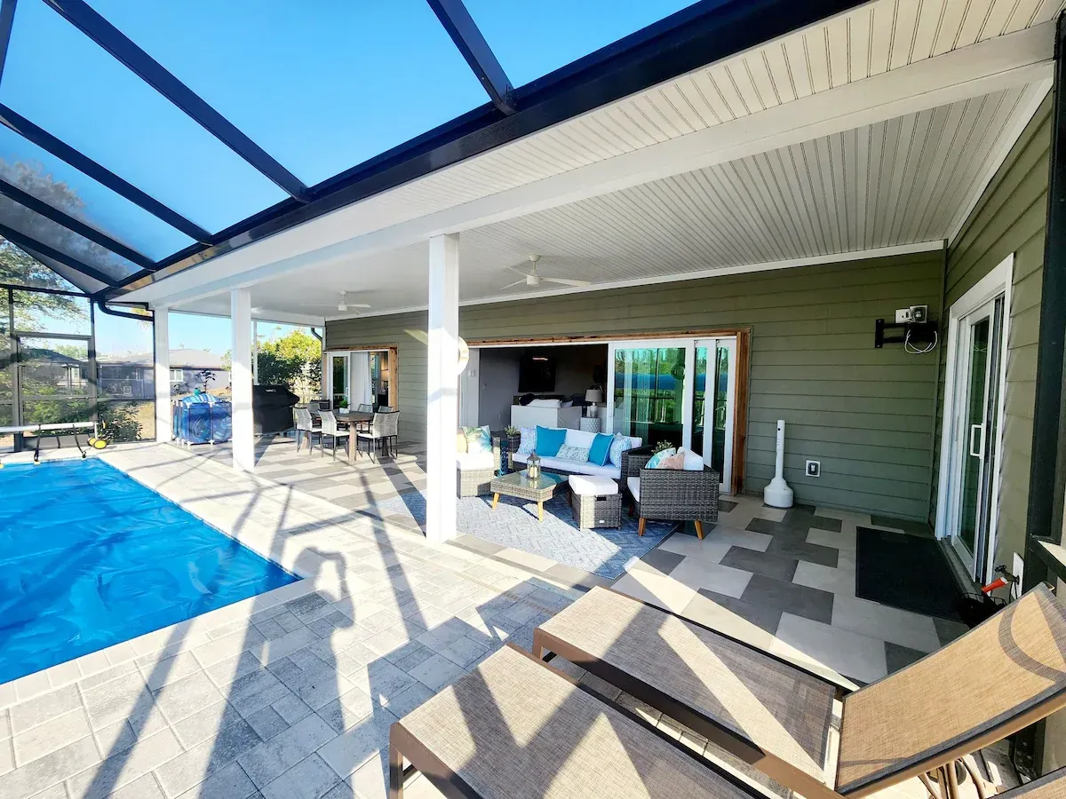 There is a large swimming pool in the backyard of a house.