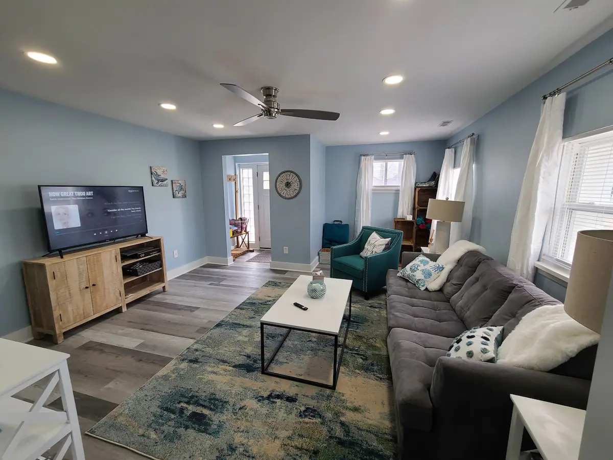 A living room with a couch, chair, coffee table and television.