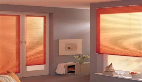 interno di una camera da letto con tende plissettate arancioni