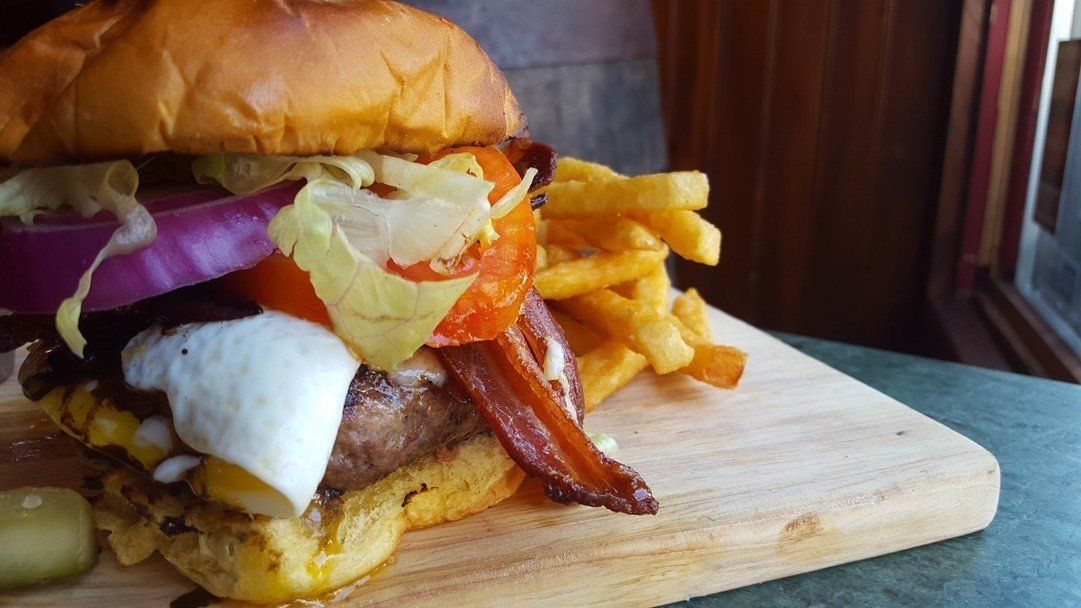 photo of cheeseburger with bacon and egg on it