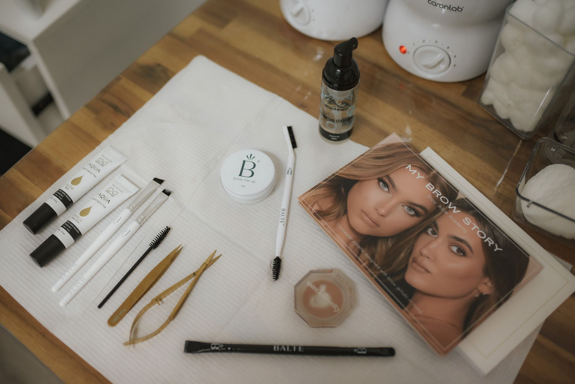 Beauty products and tools arranged on a white cloth.