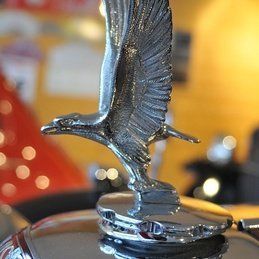 Un gros plan d'une statue d'aigle au sommet d'un capot de voiture.