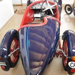 Une voiture de course bleue et rouge avec une plaque d'immatriculation qui dit cf