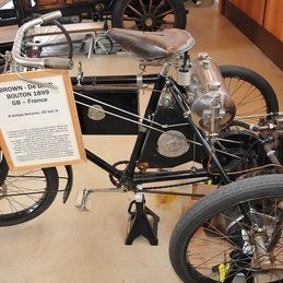 Un vieux vélo à trois roues est exposé dans un musée.