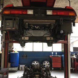 Une voiture est assise au sommet d'un ascenseur dans un garage.