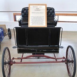 Une calèche noire avec un panneau dessus.