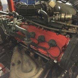 Un gros plan d'un moteur rouge dans un garage.