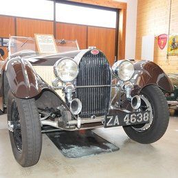 Une vieille voiture de sport bugatti est garée dans un garage.
