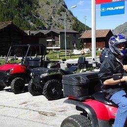 Un homme conduit un VTT rouge à côté d'une rangée d'autres VTT.