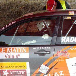 Un homme est assis sur le siège conducteur d'une voiture de course.