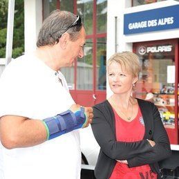 Un homme avec un plâtre au bras parle à une femme.