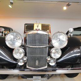 Une voiture vintage noire est garée dans un garage.