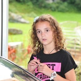 Une jeune fille se tient devant une fenêtre et tient une étoile.