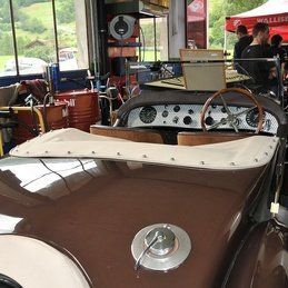 Une voiture marron est garée dans un garage avec un volant.