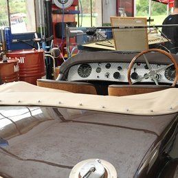 Un gros plan du tableau de bord d'une vieille voiture dans un garage.