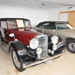 Deux vieilles voitures sont garées l'une à côté de l'autre dans un garage.