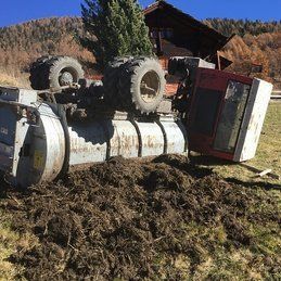 Un tracteur est retourné sur le côté dans un champ.