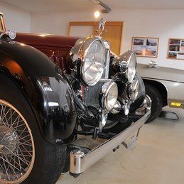 Une voiture noire est garée dans un garage à côté d'une voiture argentée.